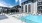 Austin, TX, Apartments Near Dripping Springs - The View at Belterra - Multi-Section Pool with Lounge Chairs, Potted Plants, and View of Apartment Complex.